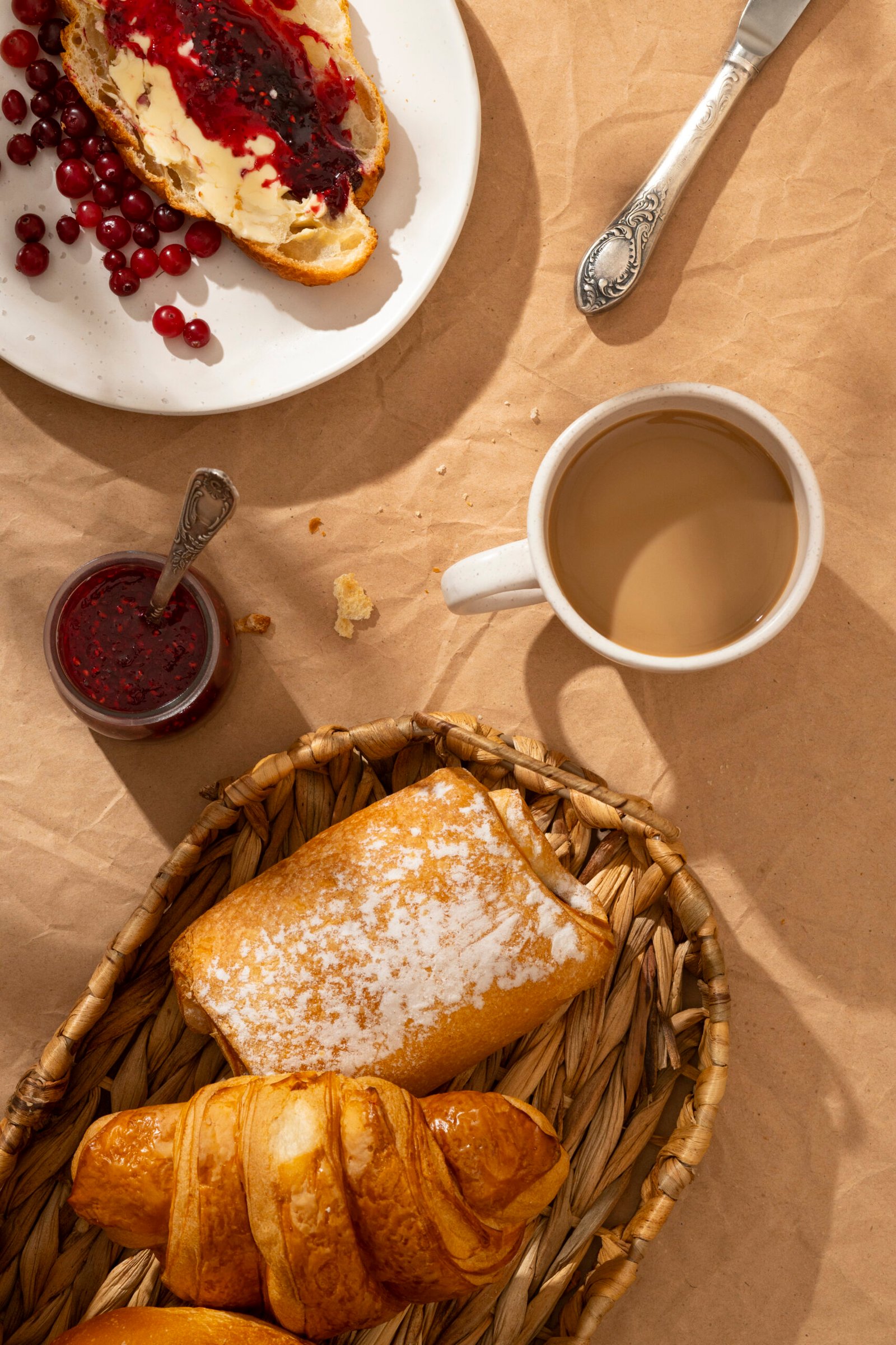 Petit déjeuner gourmand avec produits frais, pain, confitures et boissons chaudes