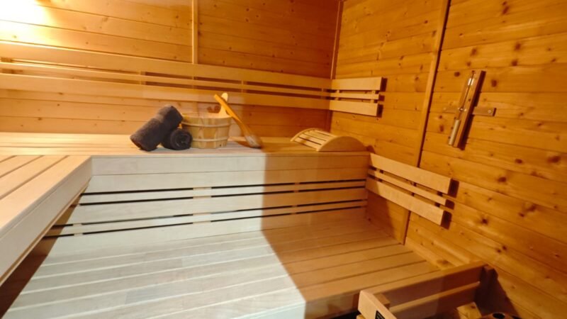Intérieur d'un sauna en bois avec bancs superposés et poêle à pierres chaudes